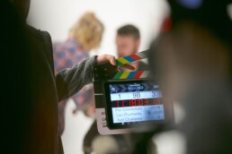 Producer preparing to film a scene. A slap slate is being used.